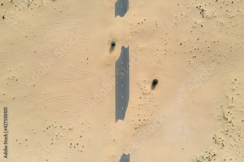 Photography Birds eye view of a sand covered empty road in the Dubai desert
