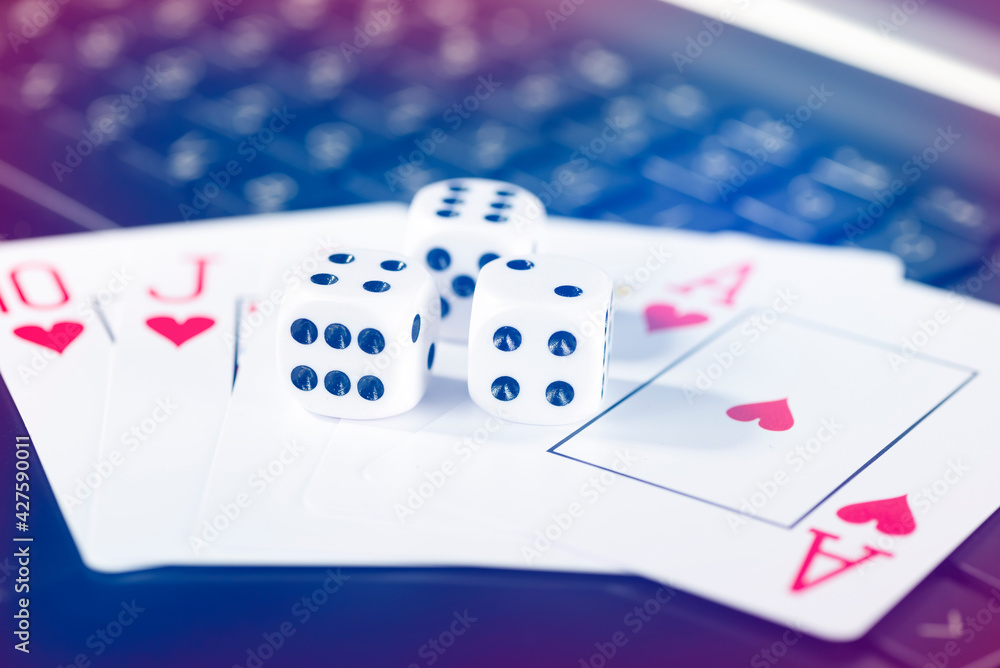 Online gaming platform, casino and gambling business. Cards, dice on laptop keyboard Online gaming platform, casino and gambling business. Cards, dice on laptop keyboard