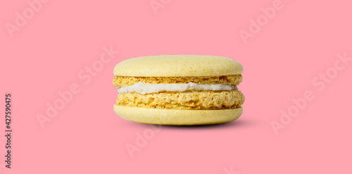 Yellow lemon macaron isolated on pink background. with a shadow