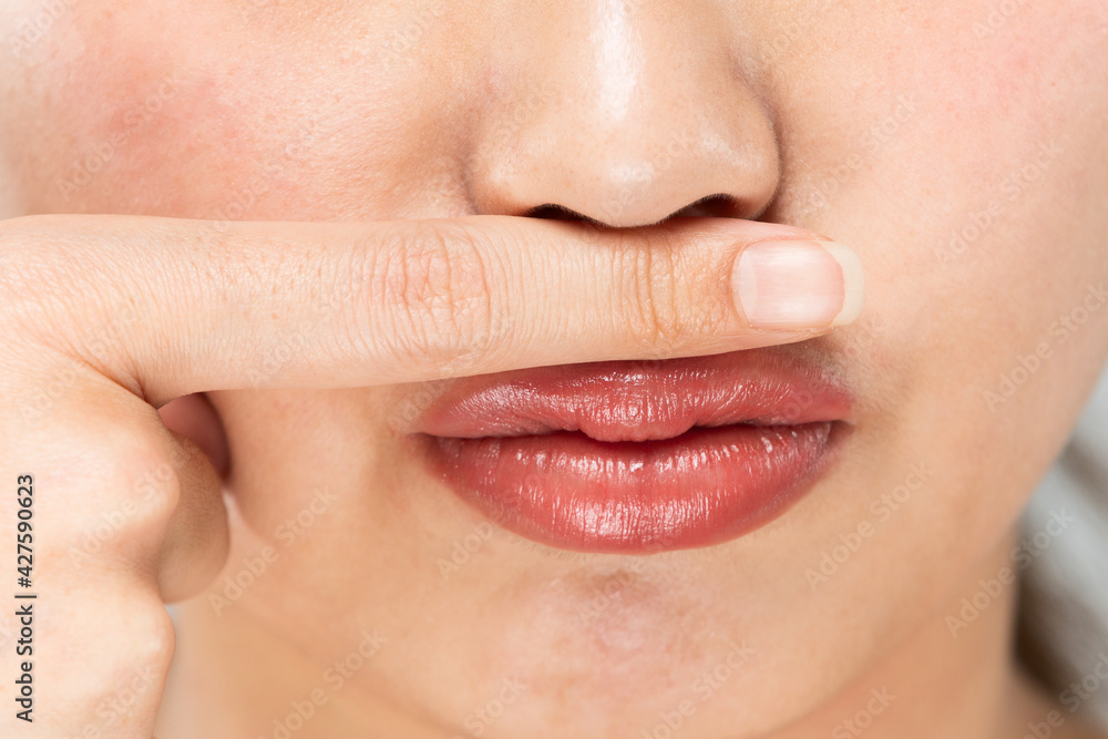 Obraz premium 鼻の下に指をおく女性