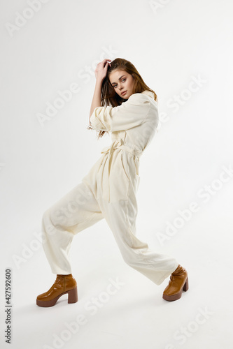 pretty woman in suit brown shoes posing light background