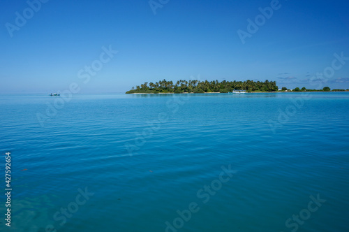Uninhabited tropical island with palm trees. empty space with beautiful turquoise lagoon