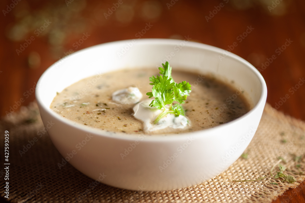 Close-up of Methi, matar malai with white curry. A popular, delicious Indian recipe in the white ceramic bowl.. Over wooden background