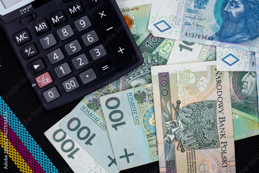 Calculator and Polish banknotes of PLN 100 and PLN 50 on a black  background. Photo taken under soft artificial light Stock Photo | Adobe  Stock