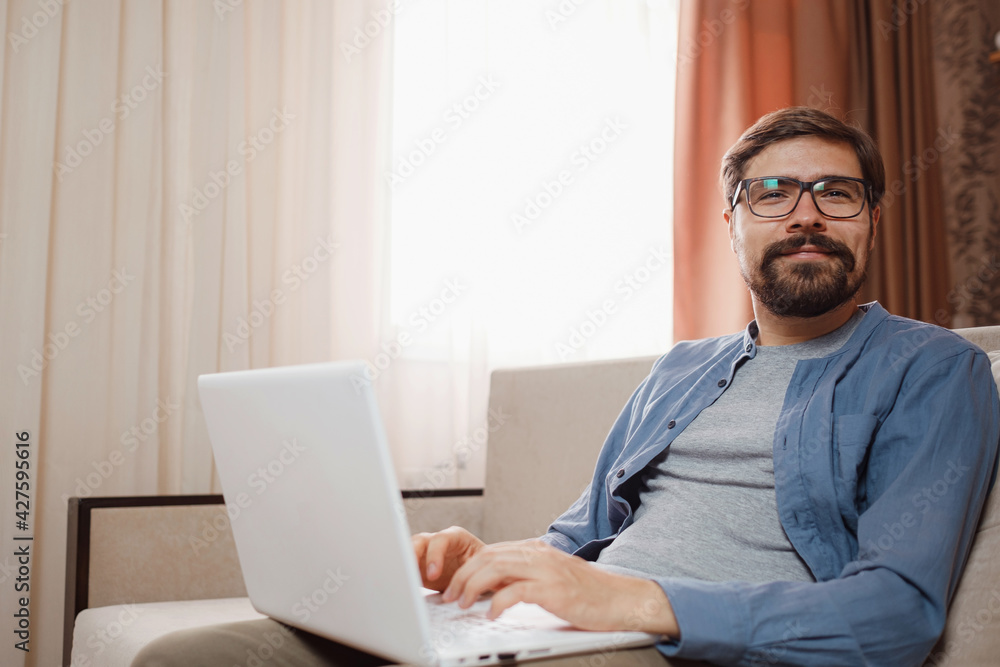 Handsome young man using laptop computer at home. Handsome young man using laptop computer at home.