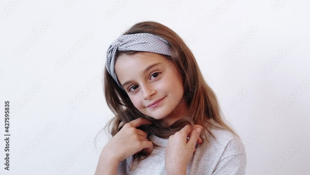 Shy kid. Child innocence. Self love admiration. Happy cheerful relaxed glad cute smiling small girl posing touching hair isolated on white background. Shy kid. Child innocence. Self love admiration. Happy cheerful relaxed glad cute smiling small girl posing touching hair isolated on white background.