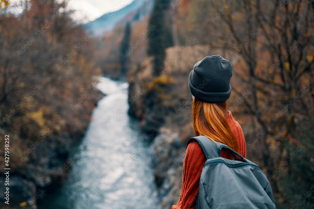 woman with backpack in nature on the bridge near the river mountains adventure woman with backpack in nature on the bridge near the river mountains adventure