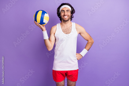 Photo of excited positive sportsman hold ball beaming smile wear glasses top shorts isolated purple background