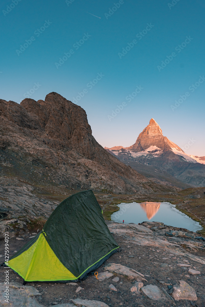 Camping in the mountain, Backpacking in Dolomites, Switzerland view to Lake and mountain. Striking panoramic landscape view of a tent.
