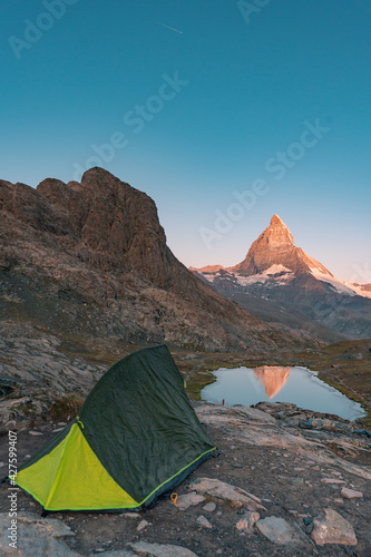 Camping in the mountain  Backpacking in Dolomites  Switzerland view to Lake and mountain. Striking panoramic landscape view of a tent. 