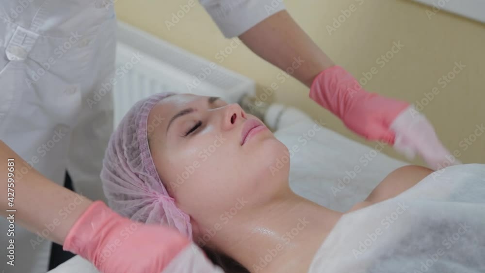 Professional beautician woman washes face to client with napkins. Professional beautician woman washes face to client with napkins.