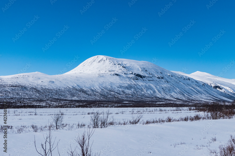 Nikkaluokta, Sweden Mountains in the Arctic landscape and blue sky.