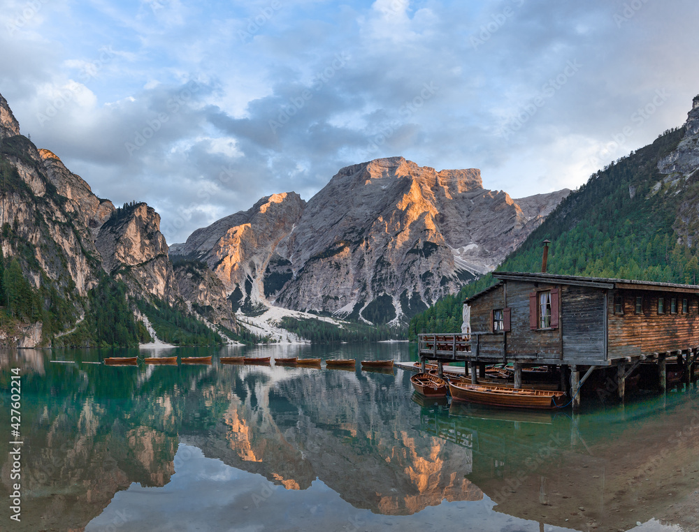 Lake Braies (Lago di Braies) in Dolomites Mountains, Boat hut on Braies Lake with Seekofel mount on background, Sunrise of Italian Alps, Naturepark Fanes-Sennes-Prags, Dolomite, Italy, Europe.
