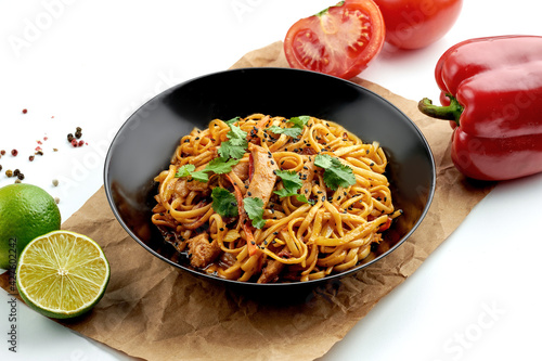 Εκτύπωση καμβά Classic Asian street food - udon wok noodles with chicken, vegetables in sweet and sour sauce, served in a black plate