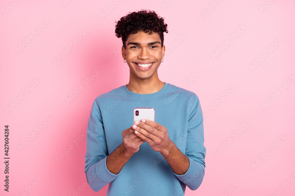 Photo of optimistic nice brunet guy write telephone wear blue sweater isolated on pastel pink color background Photo of optimistic nice brunet guy write telephone wear blue sweater isolated on pastel pink color background