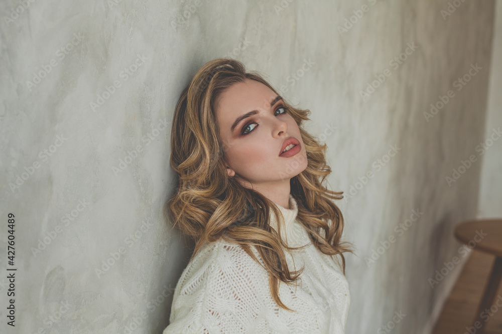 Fototapeta premium Attractive woman posing near gray stucco wall