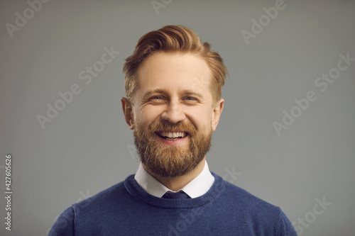 Happy cheerful man with thick beard, moustache and friendly positive smiling face. Portrait of professional entrepreneur, white collar office worker, corporate manager, college or university professor photo