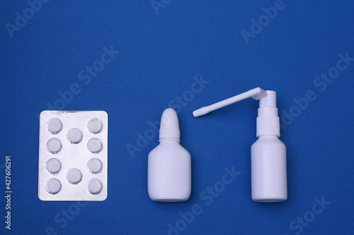 Medicines for the treatment of influenza and the virus. Throat spray, nose spray, pills. The concept of treating the virus and flu. On a blue background. Close-up. copy space