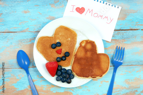 Heart shaped pancakes with blueberry and strawberry. Breakfast for mom on mother's day.