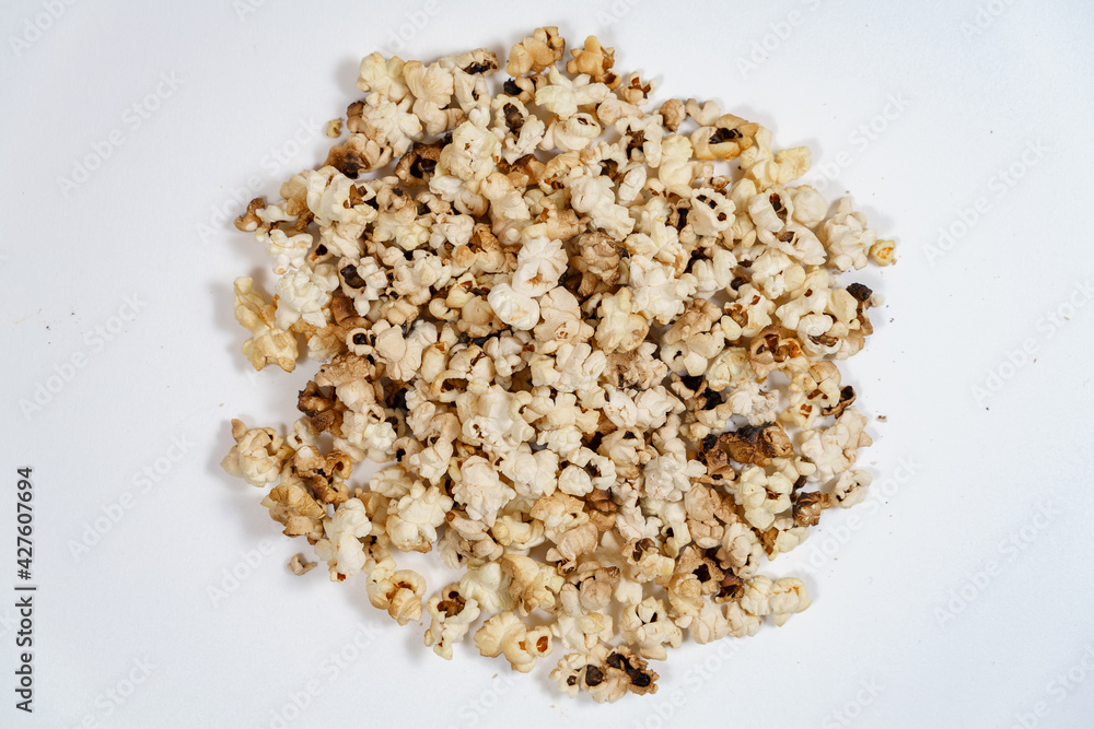spoiled burnt popcorn grains on white background spoiled burnt popcorn grains on white background