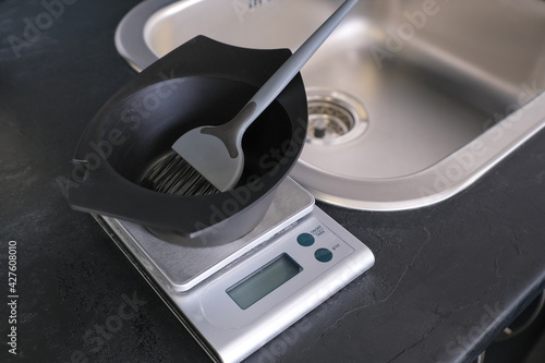 Hair dye measuring and mixing kit. Mixing bowl and hair dye brush on electronic scale. Hair coloring tools set. Professional instrument for hair colorist and hairstylist.