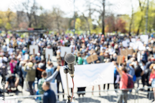 Protest or public demonstration, focus on microphone, blurred crowd of people in the background photo