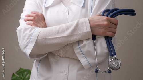 Doctor in a white coat holds a stethoscope in his hand, close-up, cardiovascular practice, hospital medical services business, the concept of health and proper treatment, seeking help from a