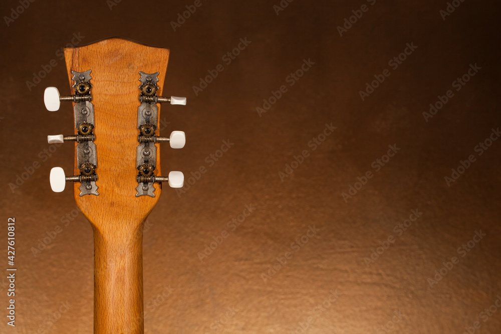 Naklejka premium Back of the acoustic guitar head on a blurred background.