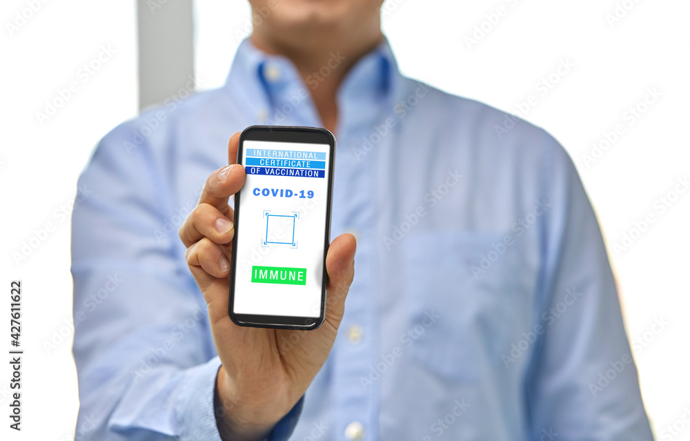 technology and health care concept - close up of man showing smartphone with virtual immunity passport or international certificate of vaccination on screen at office technology and health care concept - close up of man showing smartphone with virtual immunity passport or international certificate of vaccination on screen at office