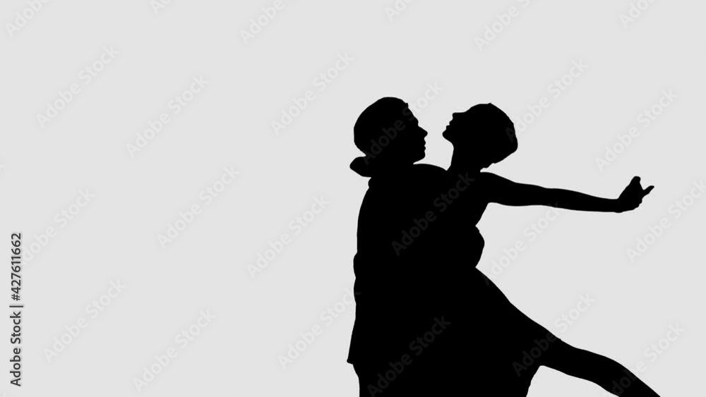 Silhouette professional ballet pair practicing moves on dark stage. Gracefulness and tenderness in every movement. Silhouette professional ballet pair practicing moves on dark stage. Gracefulness and tenderness in every movement.