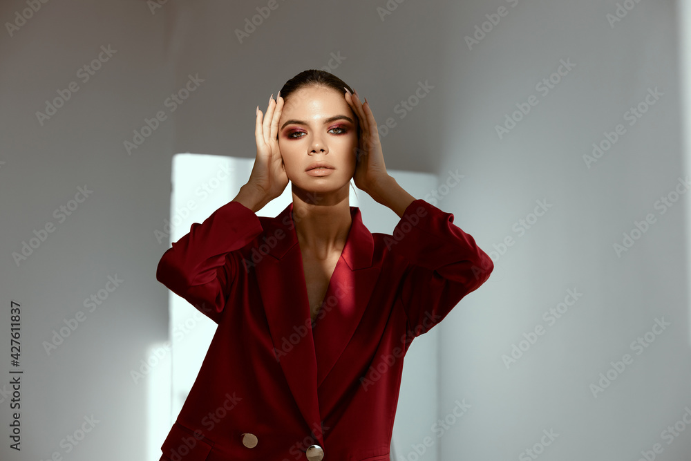 extravagant lady with bright makeup on her face touches her head with her hands extravagant lady with bright makeup on her face touches her head with her hands