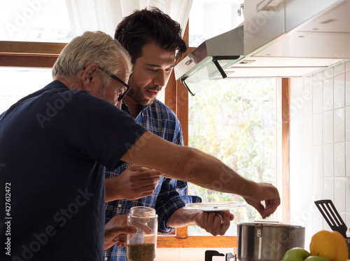 Father and son spend quality time together, cooking in the kitchen at home.