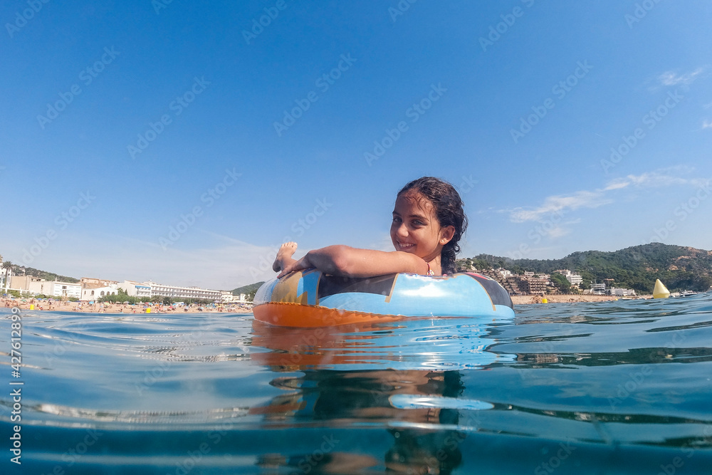 Little girl on an inflatable in the sea