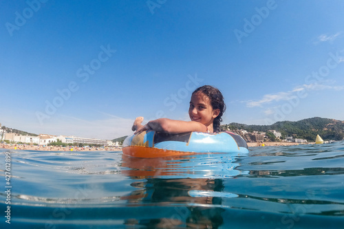 Little girl on an inflatable in the sea