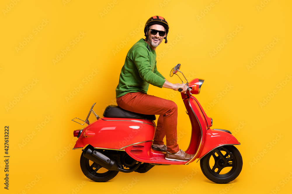Photo of man drive bike wear helmet sunglass green pullover pants footwear isolated yellow color background Photo of man drive bike wear helmet sunglass green pullover pants footwear isolated yellow color background
