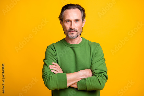 Photo of bearded confident man folded arms look camera wear green sweater isolated yellow color background