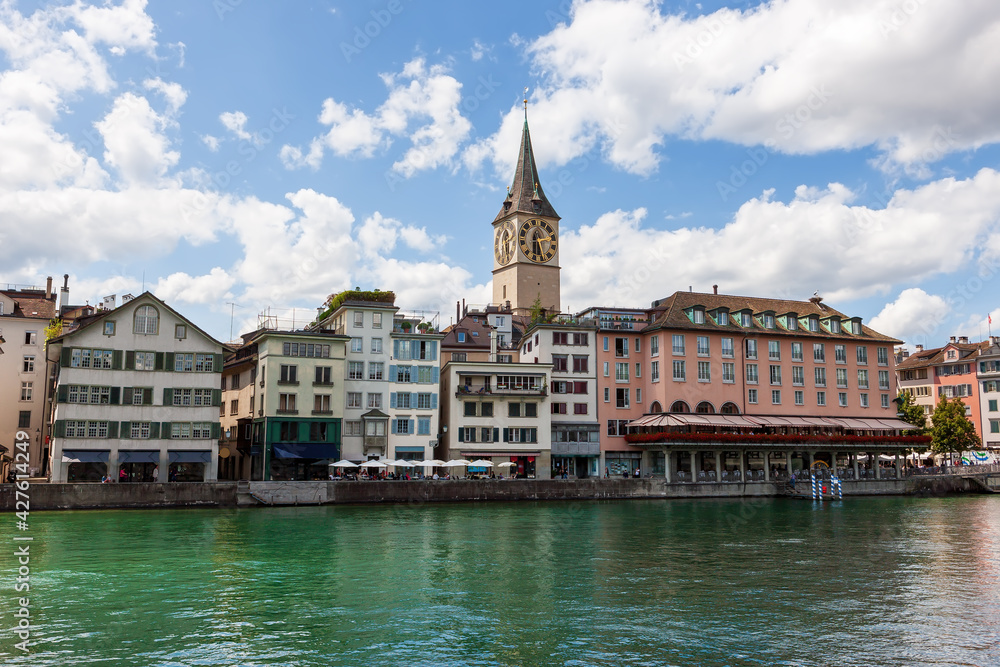 Clock tower of St. Peter's Church, view the banks of the Limmat River. Zurich, Switzerland.