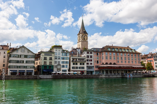 Clock tower of St. Peter's Church, view the banks of the Limmat River. Zurich, Switzerland.