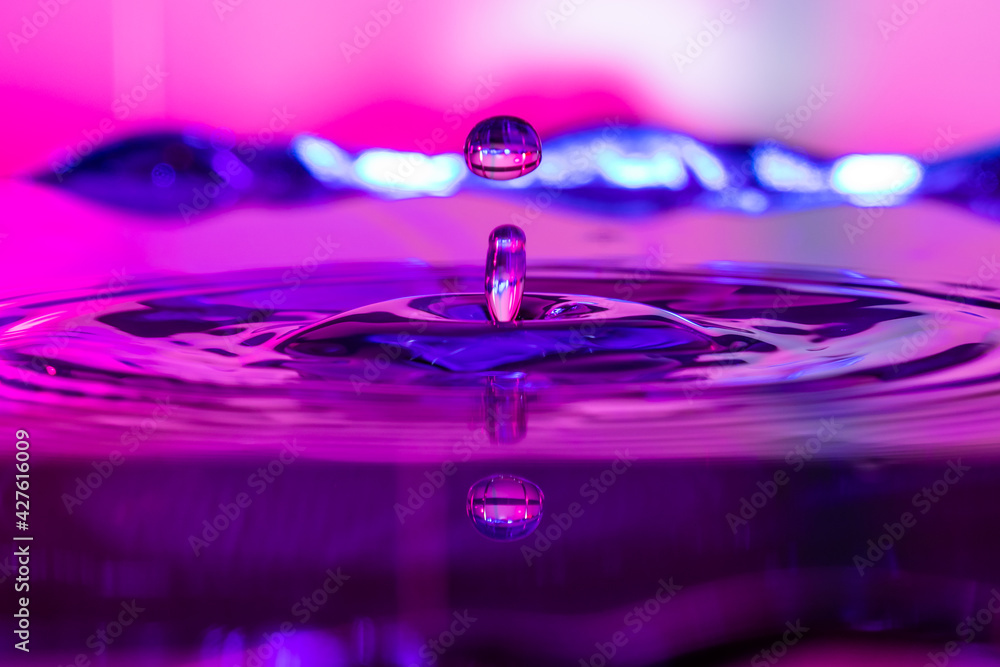 Reflejo de una gota de agua con fondo azul y rosa Stock Photo | Adobe Stock