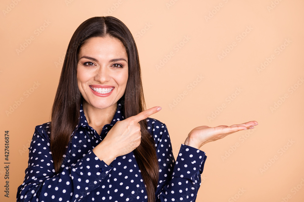 Photo of charming person direct finger empty space hand palm hold show promo isolated on beige color background Photo of charming person direct finger empty space hand palm hold show promo isolated on beige color background