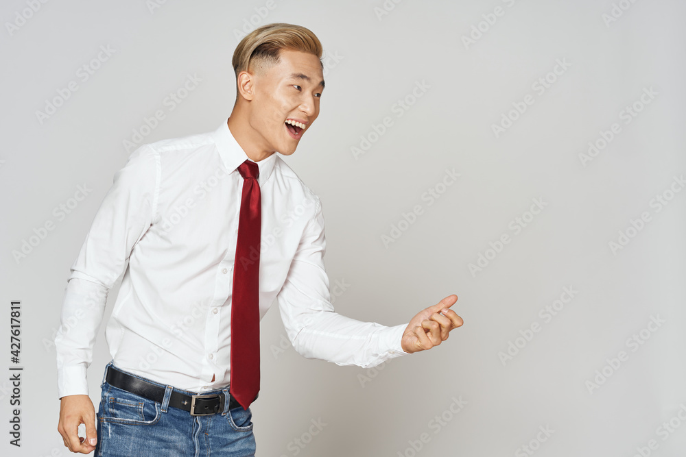 a man in a shirt tie and jeans gestures with his hands and looks to the side a man in a shirt tie and jeans gestures with his hands and looks to the side