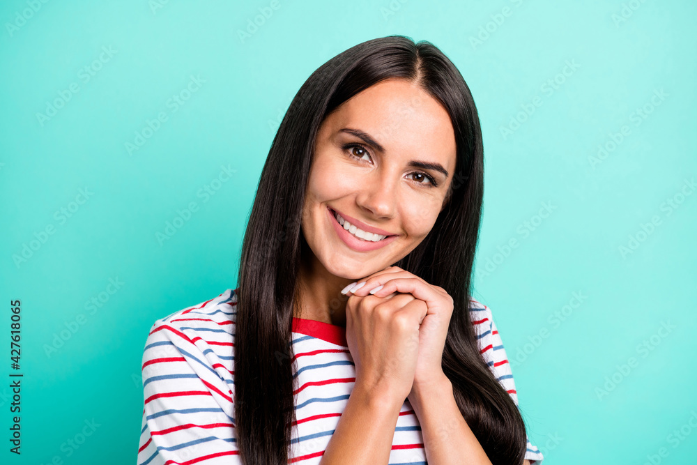 Photo of cute adorable lady beaming white smile hands chin wear striped t-shirt isolated teal color background Photo of cute adorable lady beaming white smile hands chin wear striped t-shirt isolated teal color background