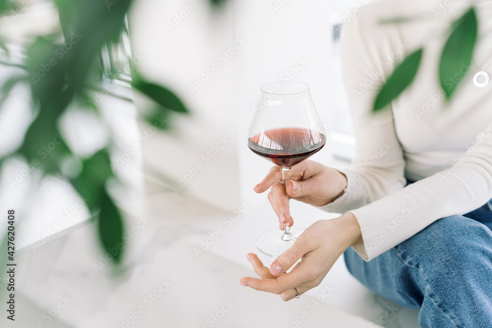 Stylish female hands holding glass with red wine Stylish female hands holding glass with red wine