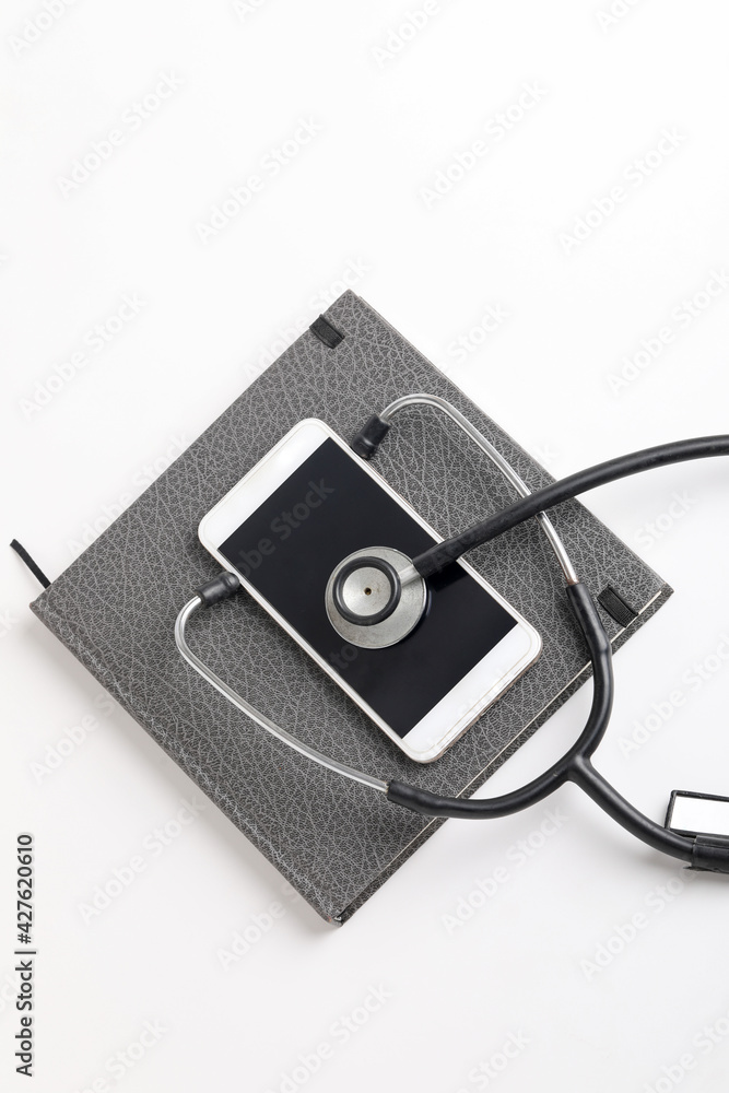 Smartphone and stethoscope on white background. Online medicine (telemedicine) technology. Service for remote diagnostic, chat with doctor. Smartphone and stethoscope on white background. Online medicine (telemedicine) technology. Service for remote diagnostic, chat with doctor.