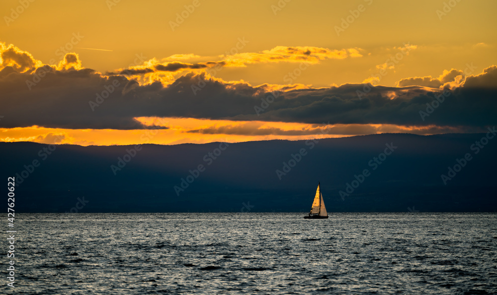 Lonely yacht on Lake Geneva at sunset in Switzerland