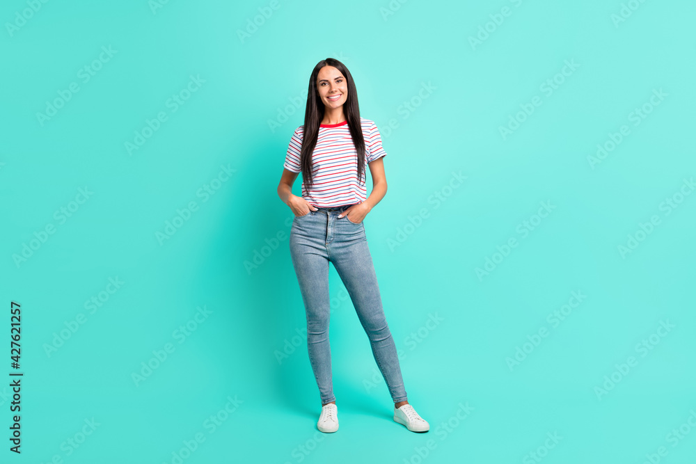 Full size photo of nice brunette optimistic long hairdo lady stand wear t-shirt jeans sneakers isolated on teal color background Full size photo of nice brunette optimistic long hairdo lady stand wear t-shirt jeans sneakers isolated on teal color background