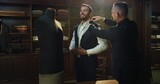 Cinematic shot of professional tailor taking measurements of client for creation custom tailored suit in a luxury tailoring atelier. Concept of fashion, handmade, hand craft, couturier and business.	