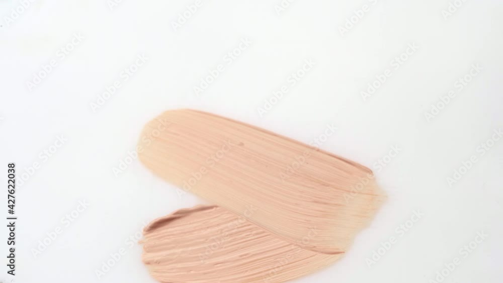 Facial foundation smudge made with a brush on white make-up palette close up Facial foundation smudge made with a brush on white make-up palette close up