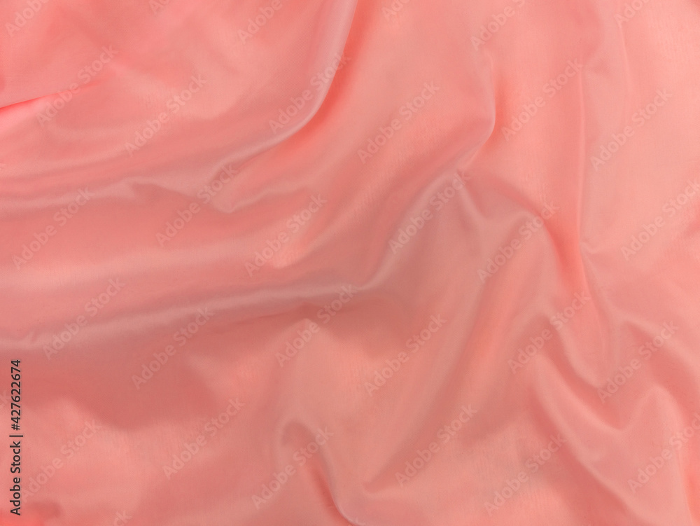 Pink silk fabric texture top view. Red coral glossy satin background. Fashion color feminine clothes trend. Female blog backdrop text sign design.Girly abstract wallpaper smooth textile surface. Pink silk fabric texture top view. Red coral glossy satin background. Fashion color feminine clothes trend. Female blog backdrop text sign design.Girly abstract wallpaper smooth textile surface.