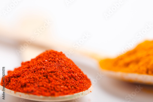 red chili powder in spoon on white background.